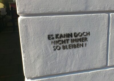 Es kann doch nicht immer so bleiben! steht auf einer weißen Hauswand